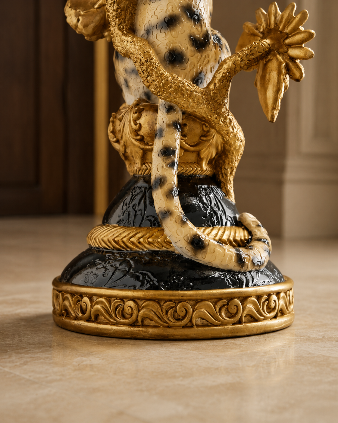 Détail du léopard, de l'oiseau et des fleurs dorées de la table d'appoint sculpturale.

