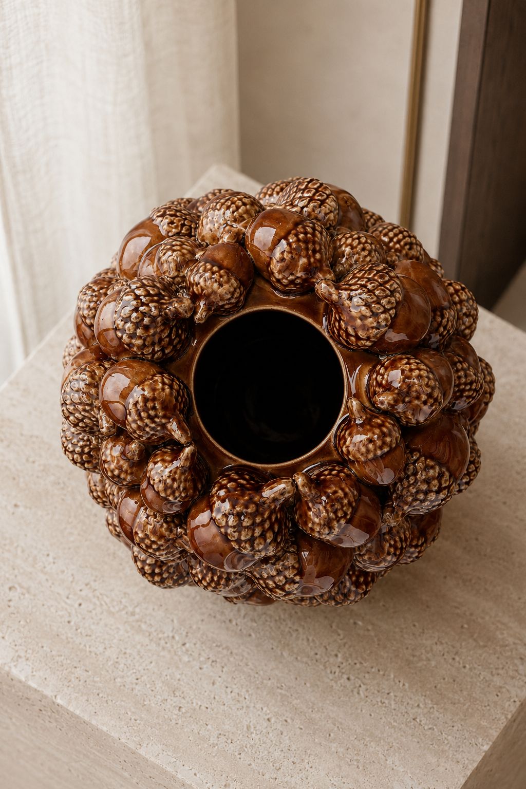Vase à glands brun en grès avec composition florale généreuse dans un intérieur élégant
