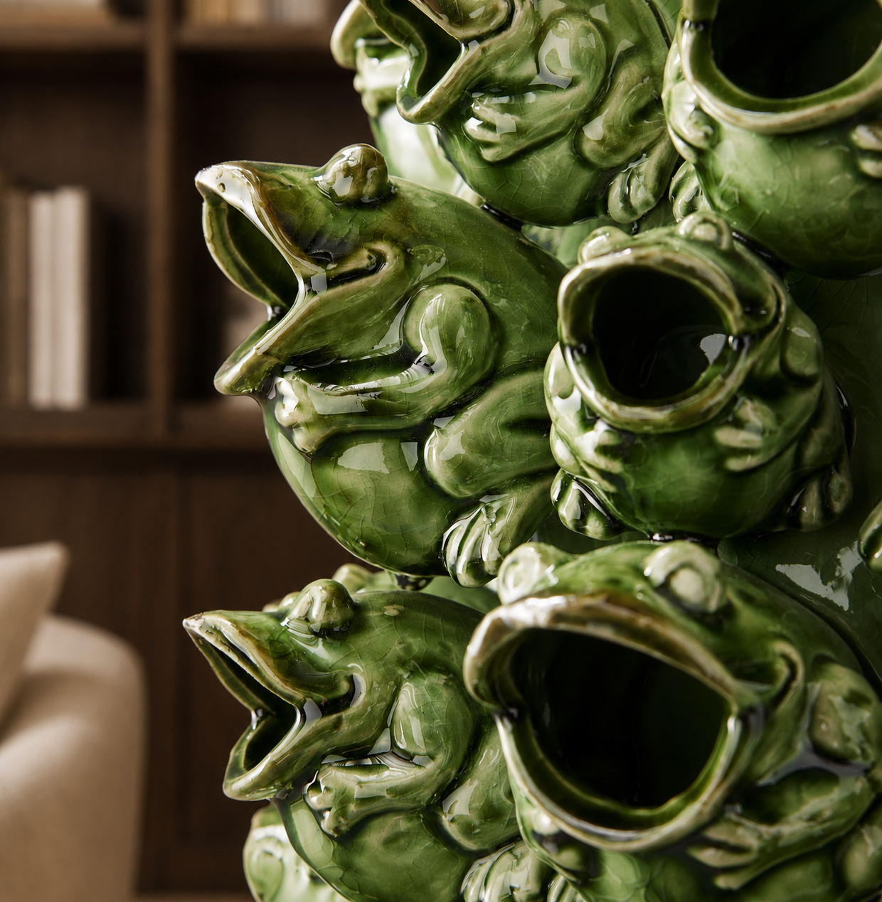 Vase sculptural en céramique verte orné de grenouilles, accompagné d’un feuillage luxuriant dans une élégante résidence méditerranéenne.